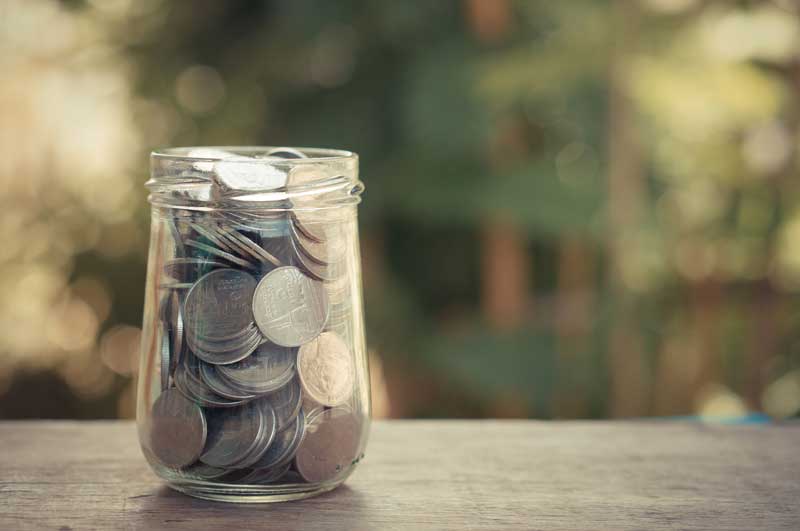 Glass jar filled with coins from VFCU harlingen credit union