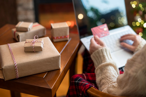 A young person shopping online through her Brownsville credit union checking account.